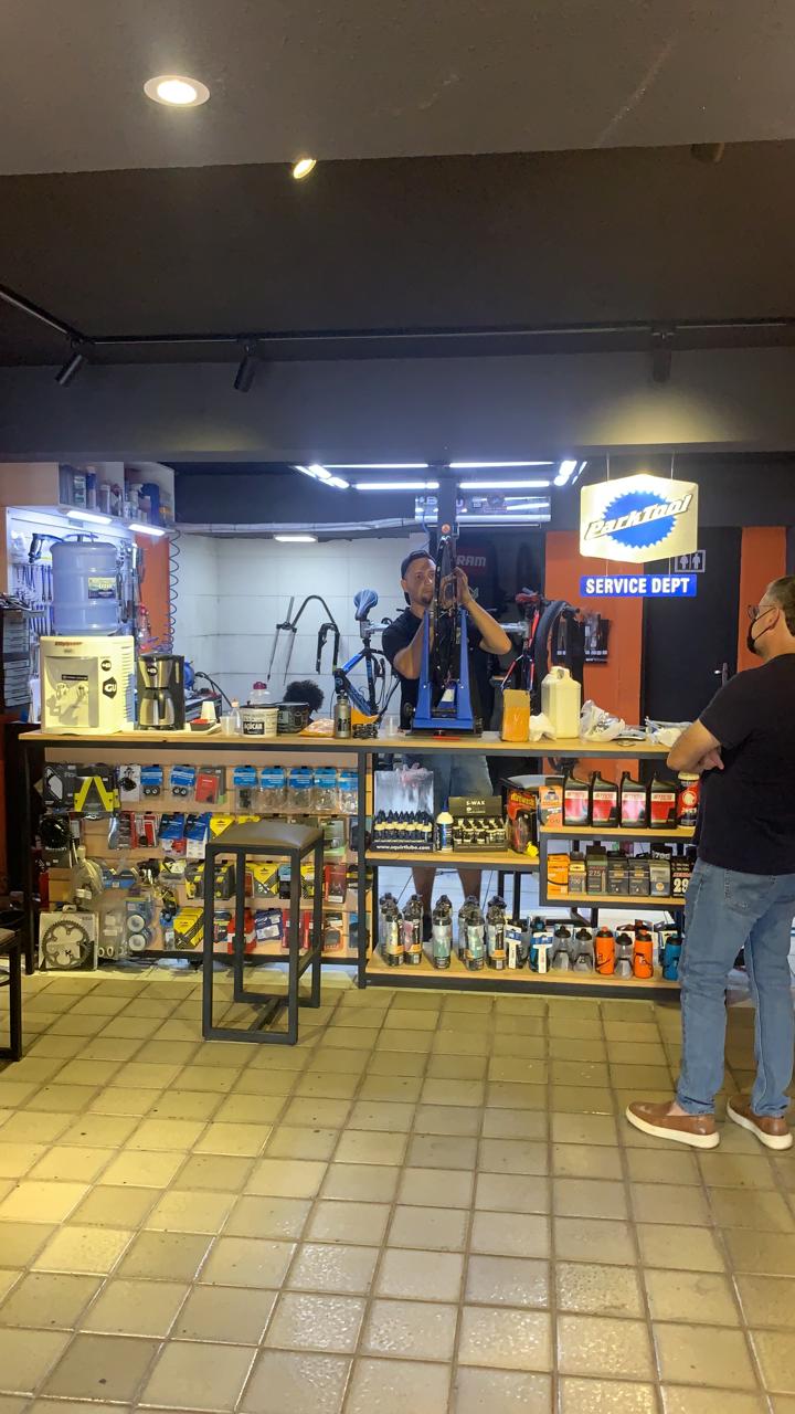 Oficina com mecânico trabalhando na bike